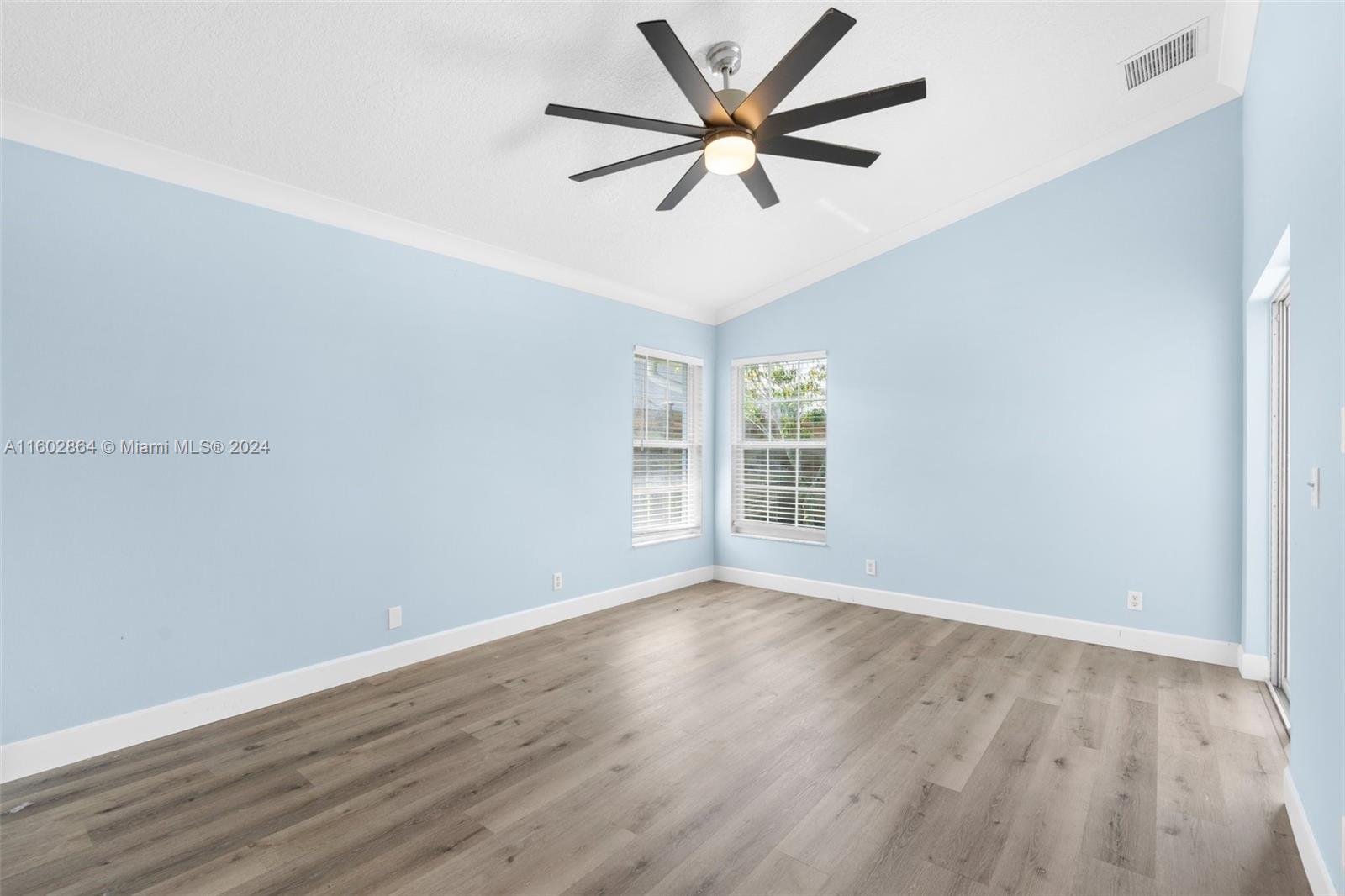 6054 Foster Street Jupiter, FL 33458 - Photo 23 of 50 an empty room with wooden floor and windows