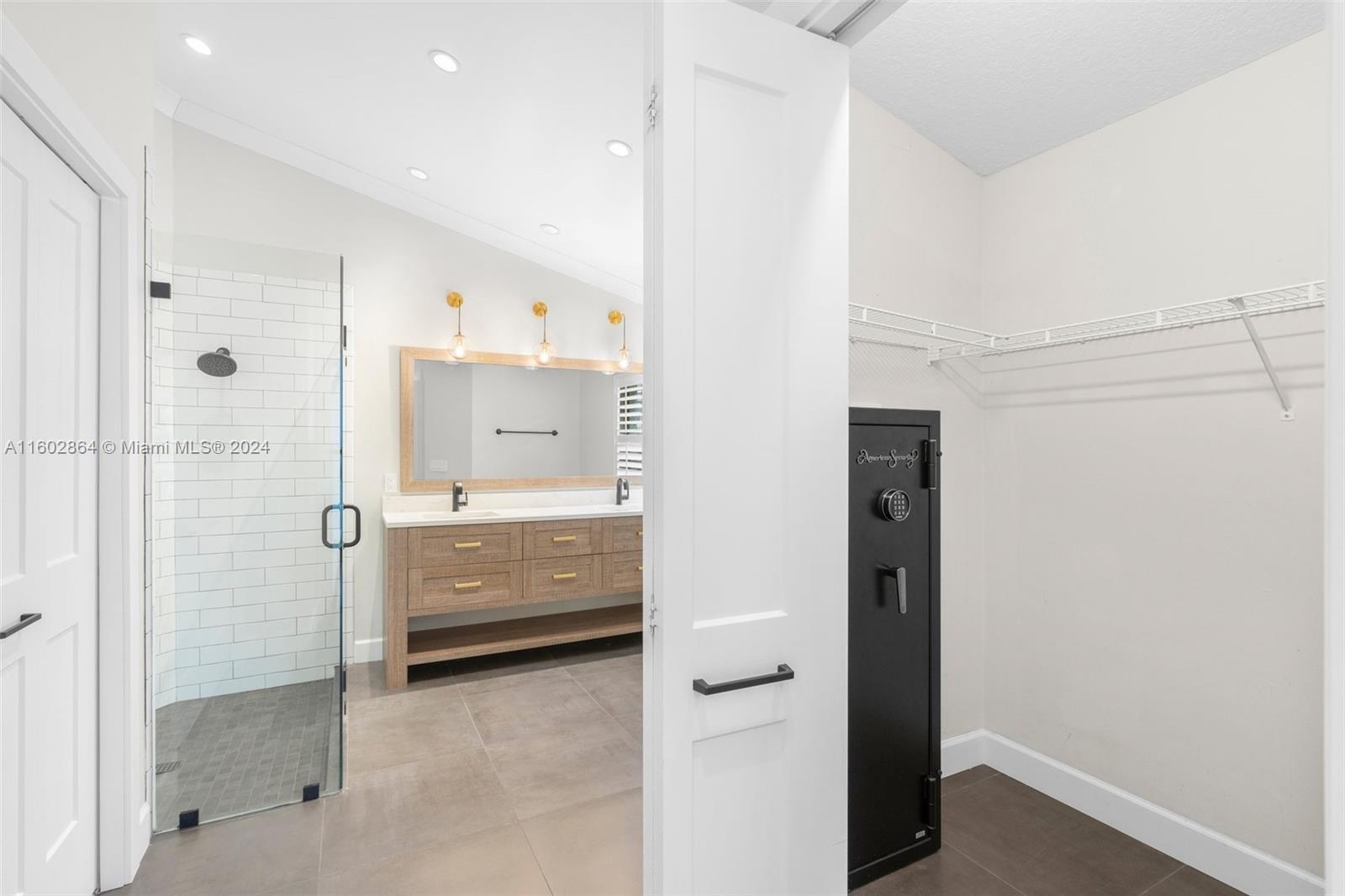 6054 Foster Street Jupiter, FL 33458 - Photo 25 of 50 a bathroom with a glass shower door and a sink
