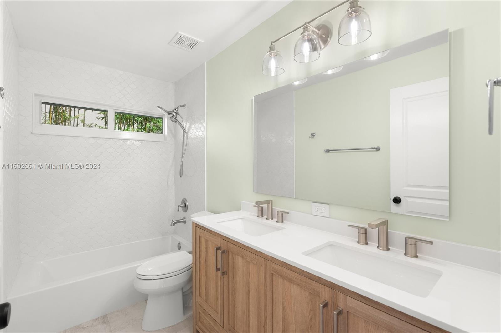 6054 Foster Street Jupiter, FL 33458 - Photo 32 of 50 a bathroom with a double vanity sink mirror and toilet