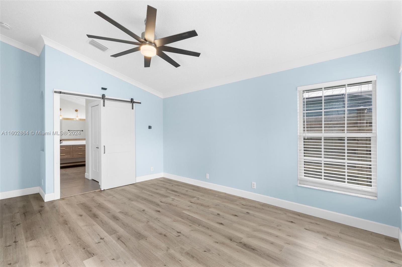 6054 Foster Street Jupiter, FL 33458 - Photo 5 of 50 a view of empty room with wooden floor and ceiling fan