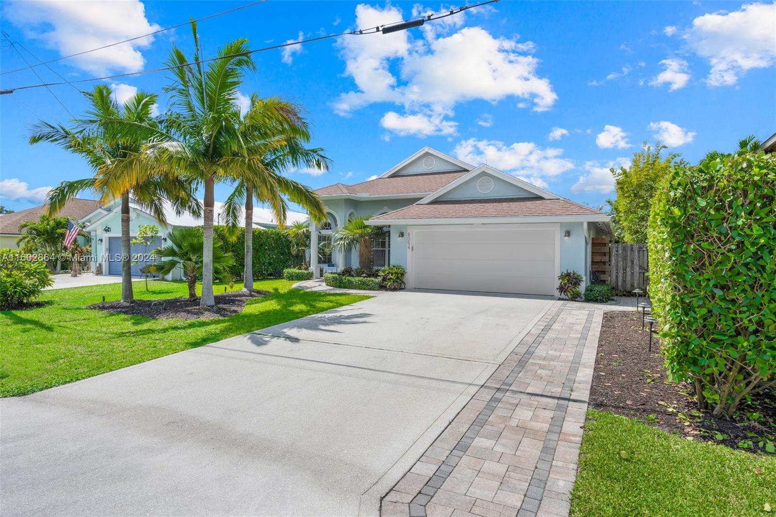 6054 Foster Street Jupiter, FL 33458 - Photo 6 of 50 a view of a house with a yard and potted plants