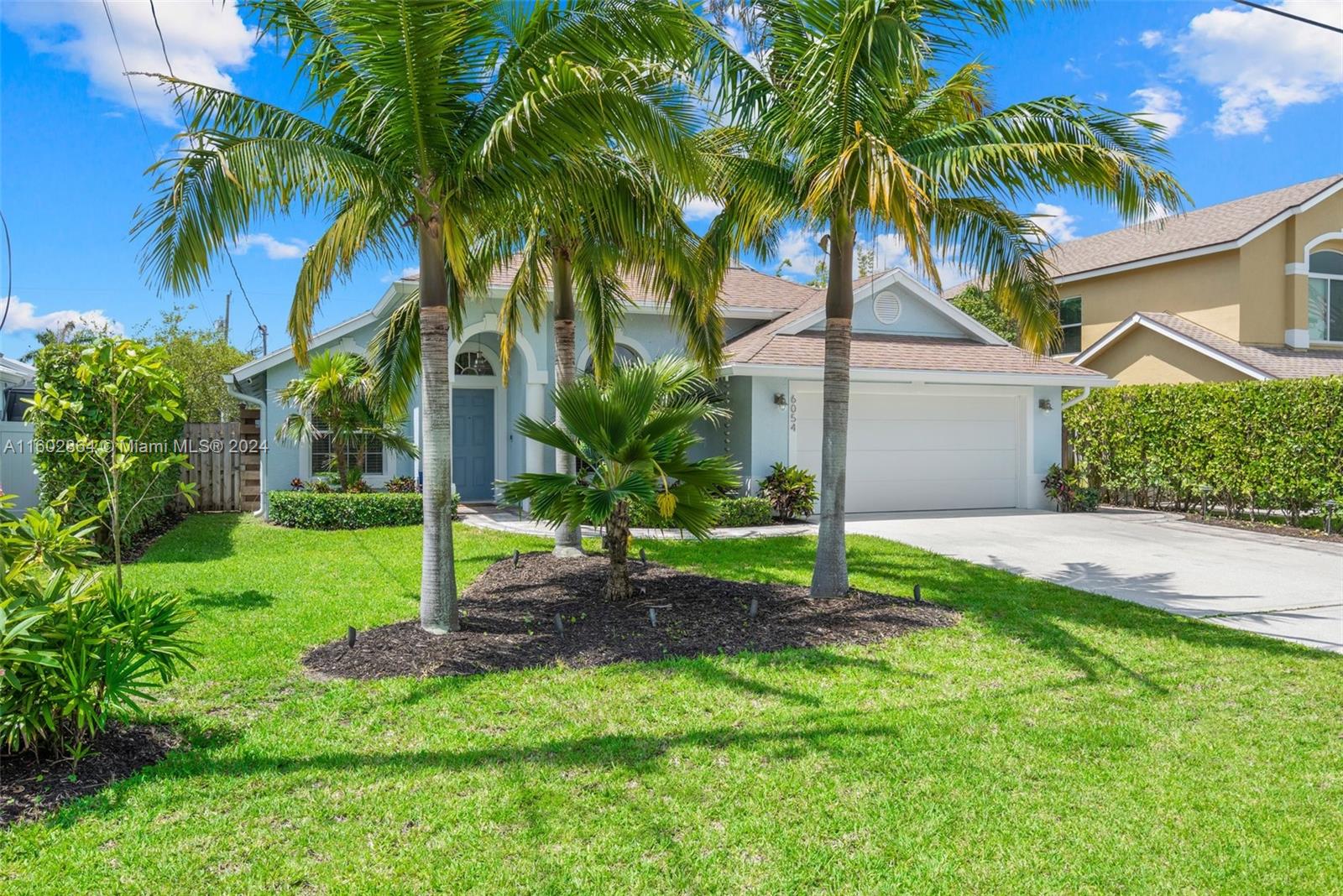 6054 Foster Street Jupiter, FL 33458 - Photo 8 of 50 a house with a garden and palm trees