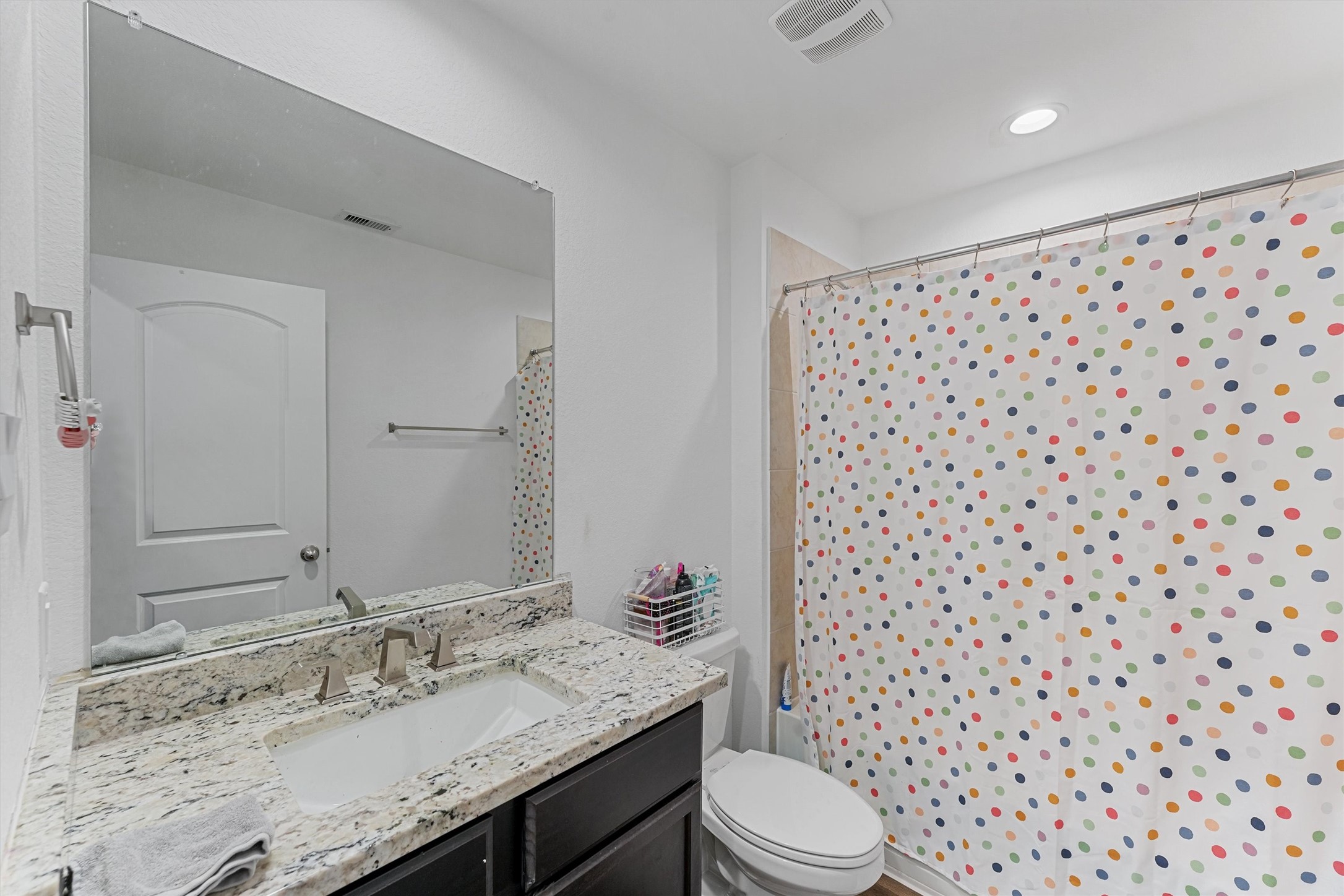 22411 Gilded Peak Lane Spring, TX 77373 - Photo 13 of 16 a bathroom with a granite countertop sink toilet a mirror and shower curtain