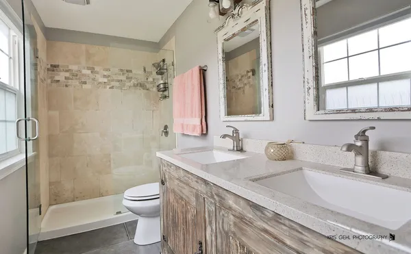 a bathroom with a granite countertop sink toilet a large mirror and shower