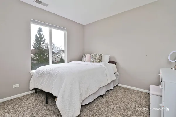 a bed sitting in a bedroom next to a window