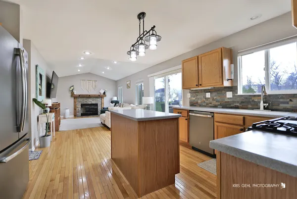 a kitchen with kitchen island granite countertop a sink appliances cabinets and a counter top space