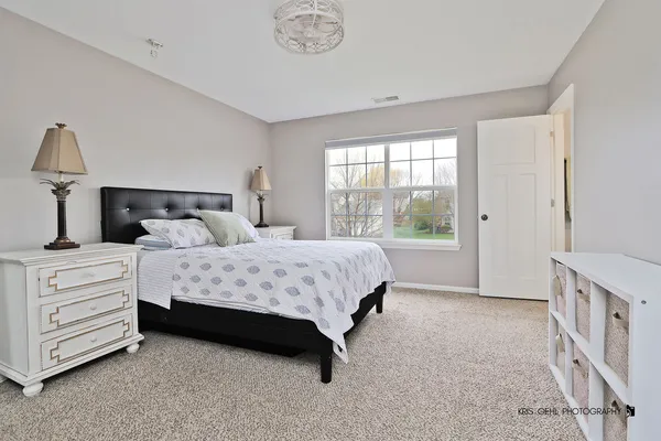 a bedroom with a bed a dresser and a window