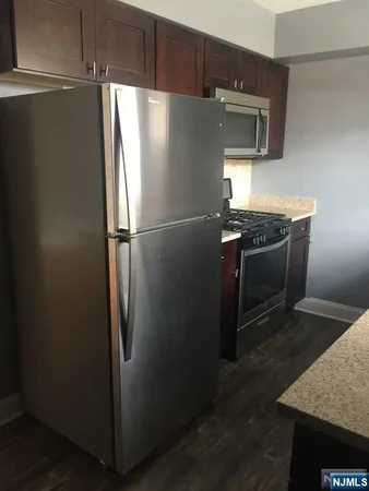 a metallic refrigerator freezer sitting in a kitchen