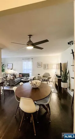 a living room with furniture and a dining table with wooden floor
