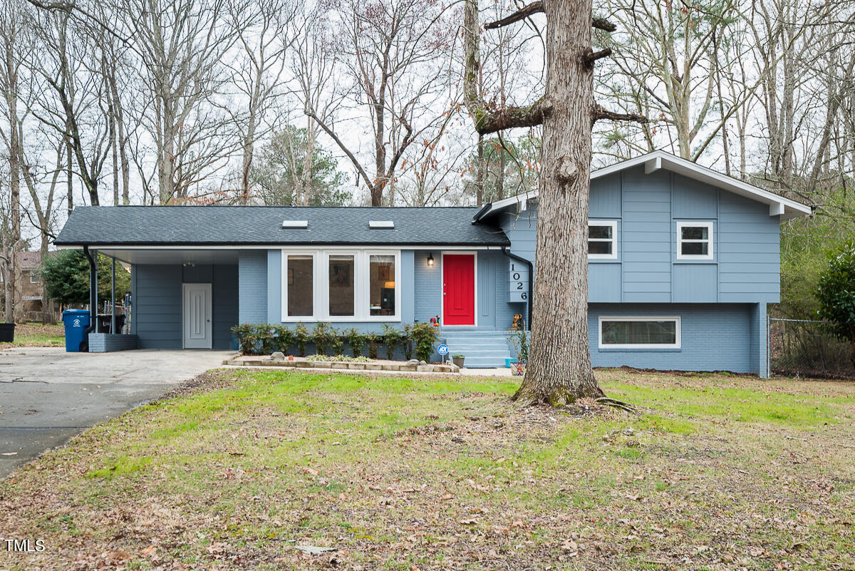 a front view of house with yard and trees around