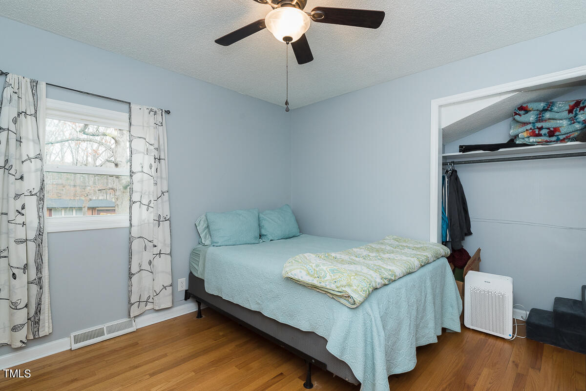 1026 Jerome Road Durham, NC 27713 - Photo 14 of 27 a bedroom with a bed and wooden floor