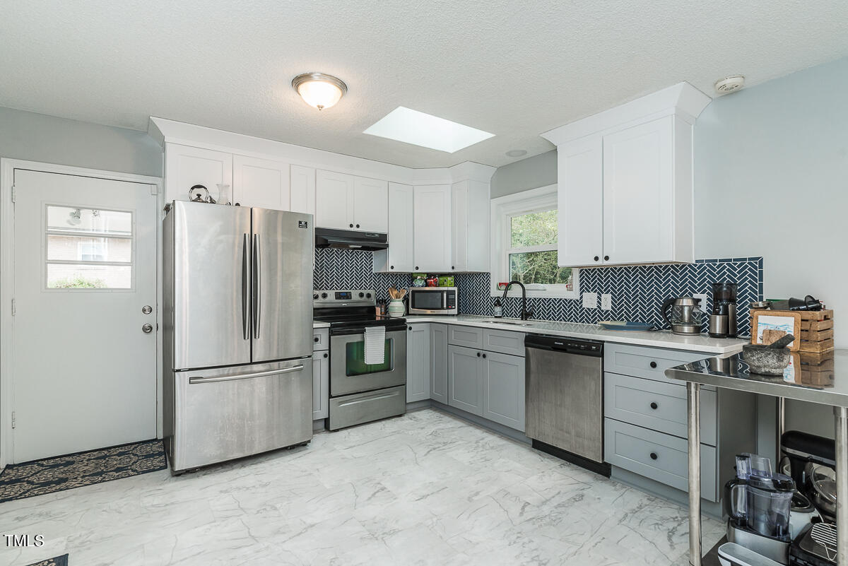 1026 Jerome Road Durham, NC 27713 - Photo 3 of 27 a kitchen with stainless steel appliances a refrigerator sink and cabinets