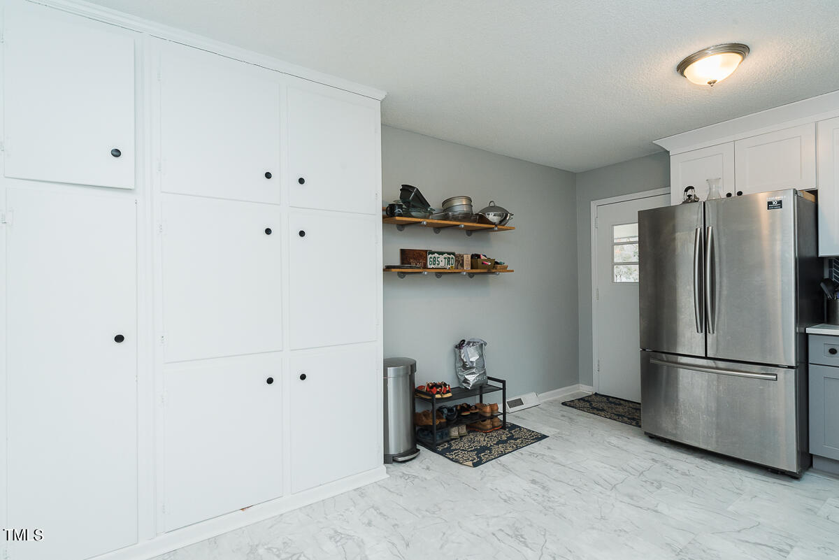 1026 Jerome Road Durham, NC 27713 - Photo 5 of 27 a kitchen with a refrigerator and a stove top oven