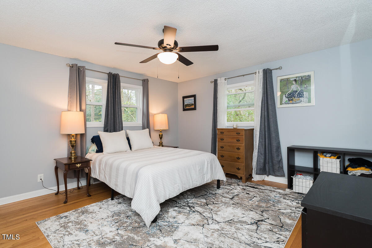 1026 Jerome Road Durham, NC 27713 - Photo 7 of 27 a bedroom with a large bed and a chandelier