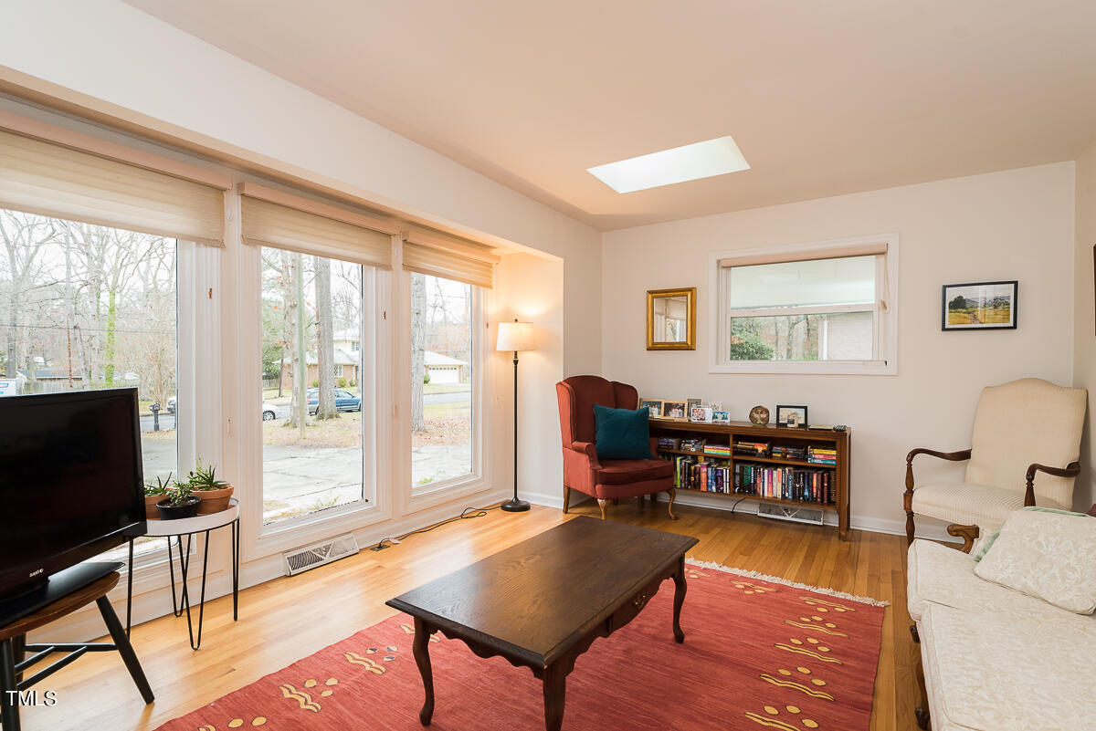 1026 Jerome Road Durham, NC 27713 - Photo 10 of 27 a living room with furniture a flat screen tv and a floor to ceiling window