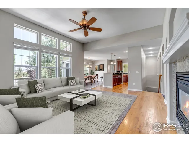 a living room with furniture kitchen view and a large window