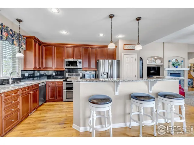 a kitchen with stainless steel appliances wooden cabinets a stove a sink and a microwave