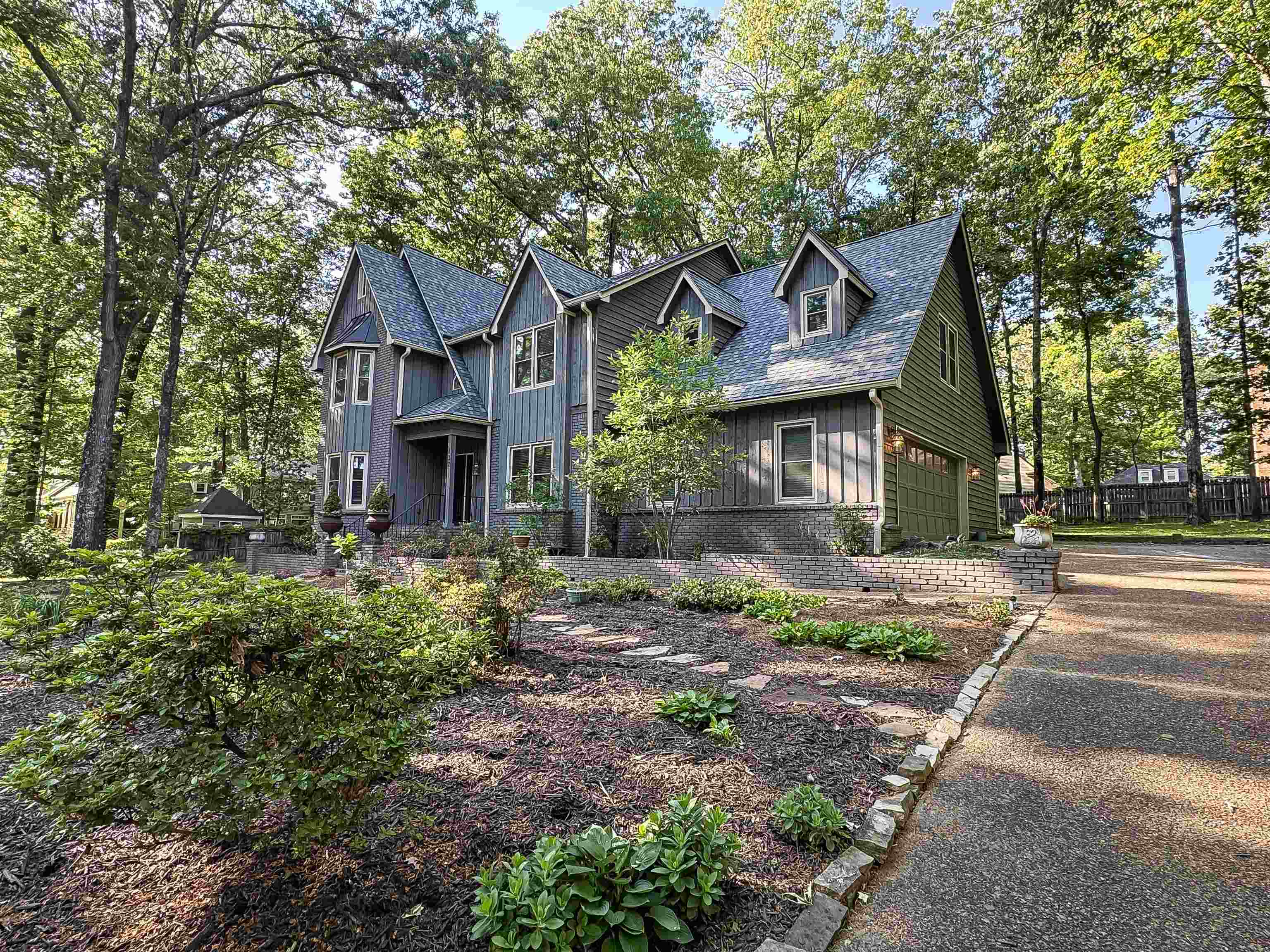 832 South Tree Drive Collierville, TN 38017 - Photo 39 of 40 Multi-gabled exterior with vertical and horizontal siding, an integrated two-car garage, multiple dormer windows, a covered front entry, and a stone-edged driveway
