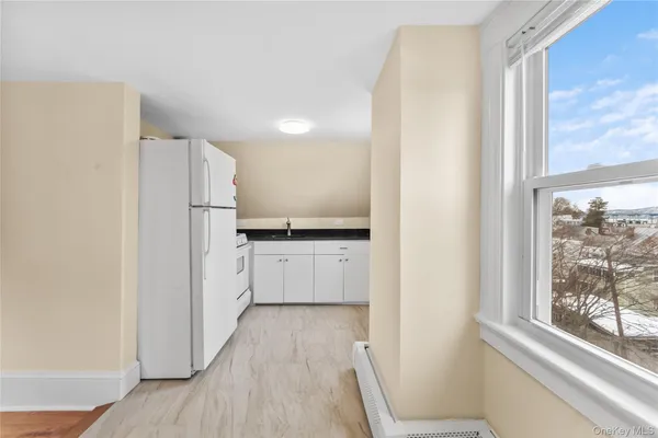 a kitchen with white cabinets and white appliances