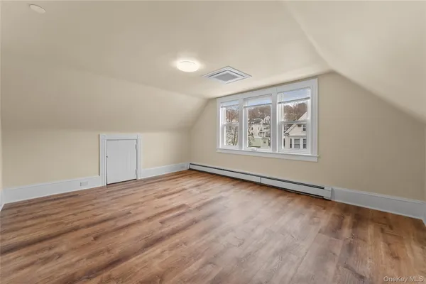 an empty room with wooden floor and window