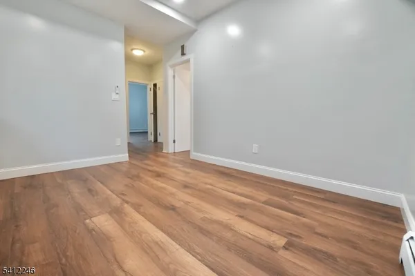 a view of empty room with wooden floor