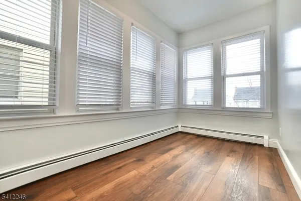 a view of a room with wooden floor and a window