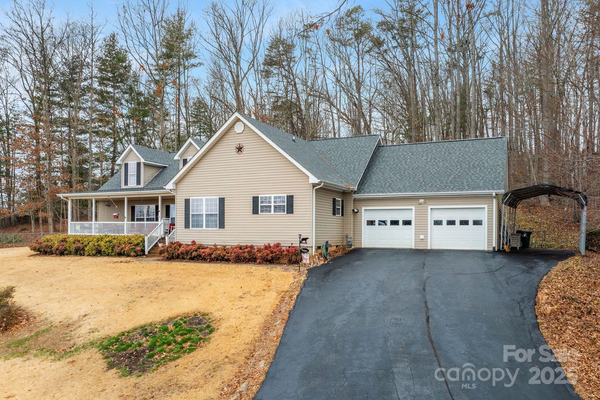 75 Pine Tree Drive Candler, NC 28715 - Photo 2 of 21 a view of a white house next to a yard with a large tree