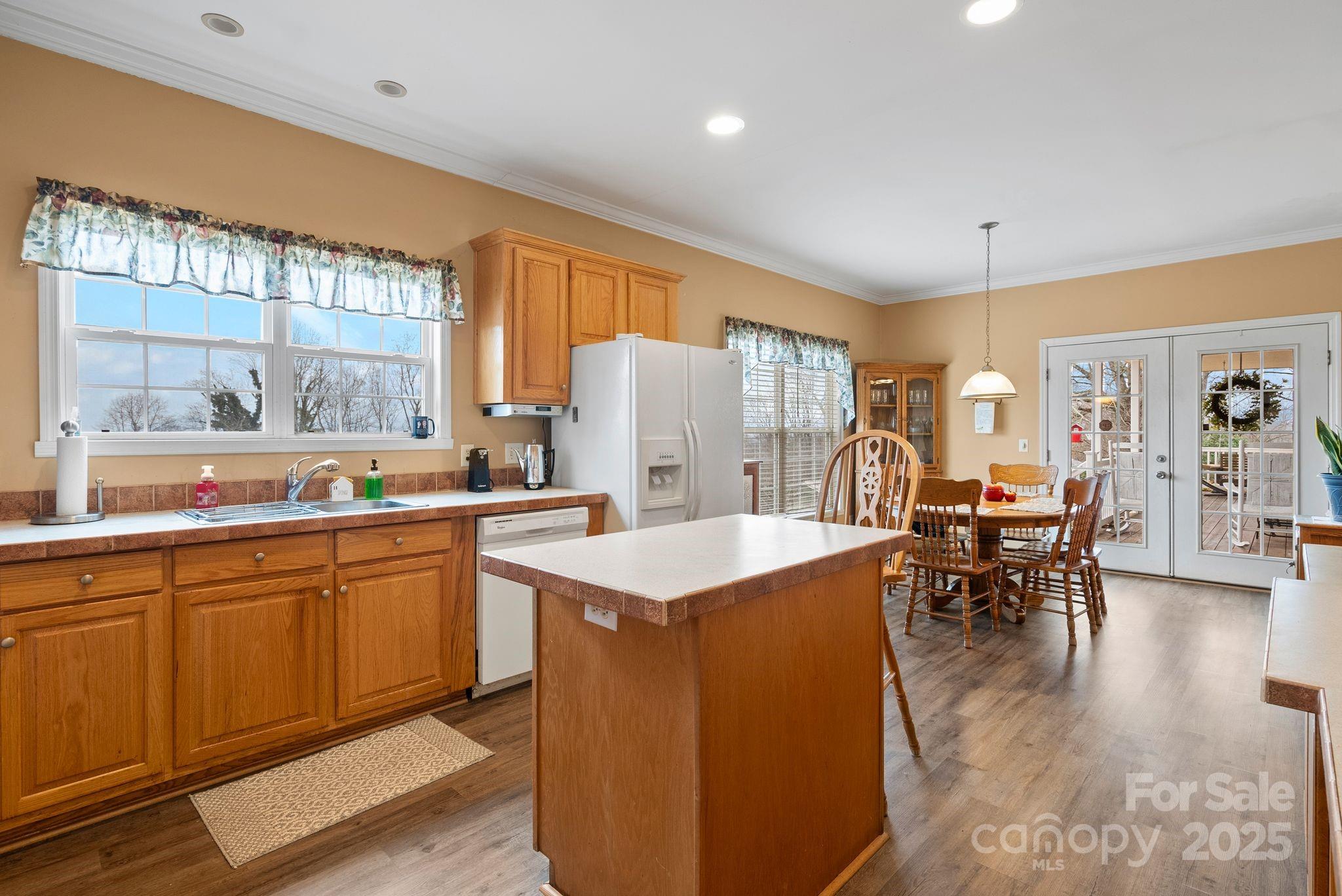 75 Pine Tree Drive Candler, NC 28715 - Photo 7 of 21 a open kitchen with stainless steel appliances granite countertop a refrigerator a sink a stove and white cabinets with wooden floor