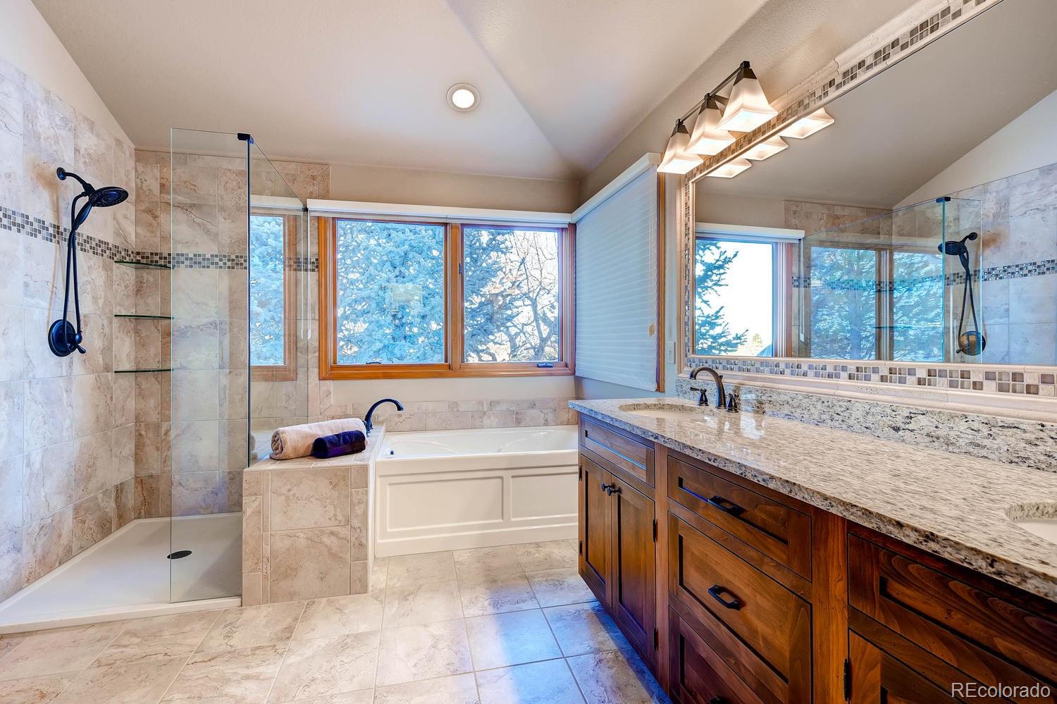 9470 Kemper Drive Lone Tree, CO 80124 - Photo 13 of 35 a bathroom with a granite countertop tub sink shower and mirror