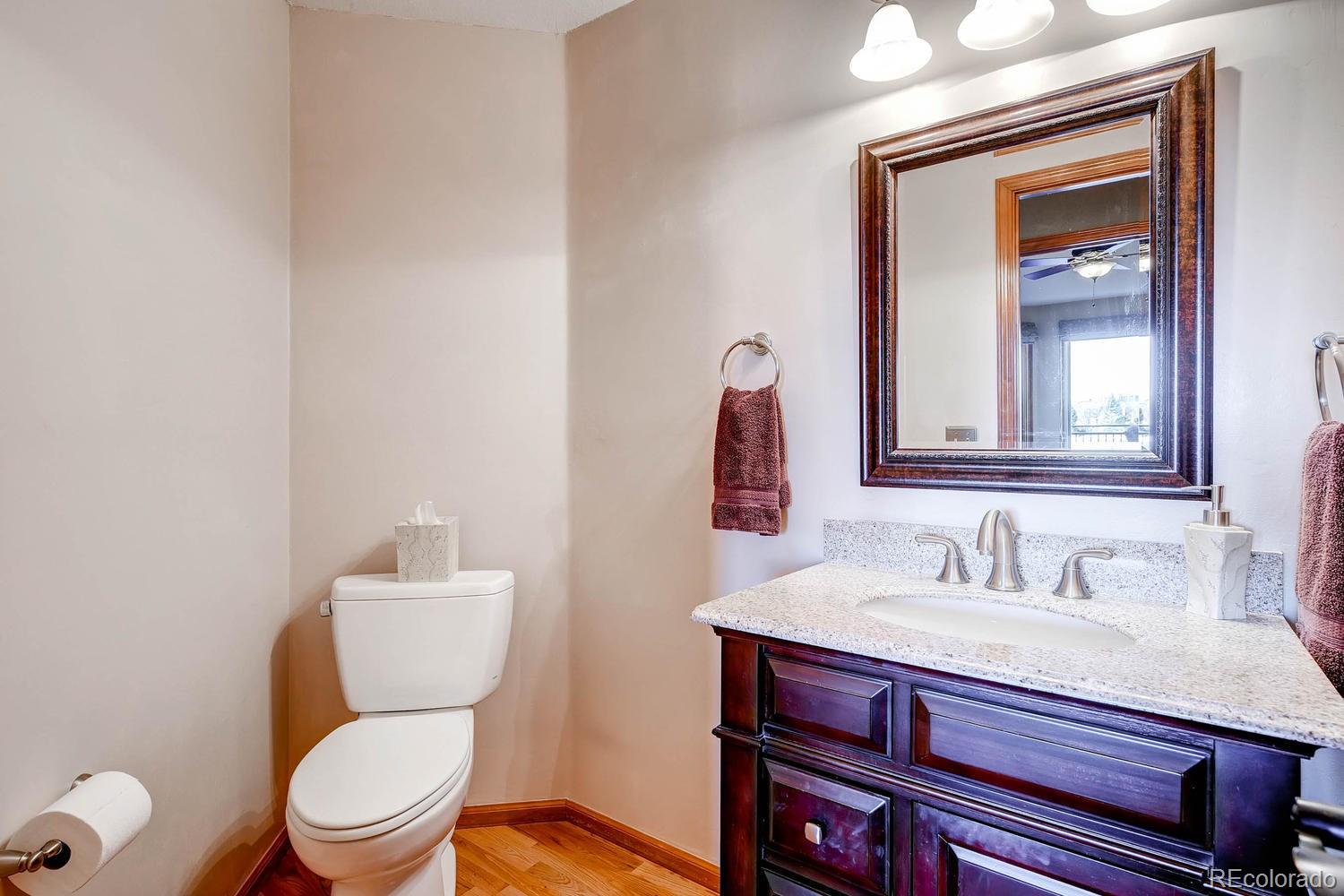 9470 Kemper Drive Lone Tree, CO 80124 - Photo 16 of 35 a bathroom with a toilet a sink and mirror