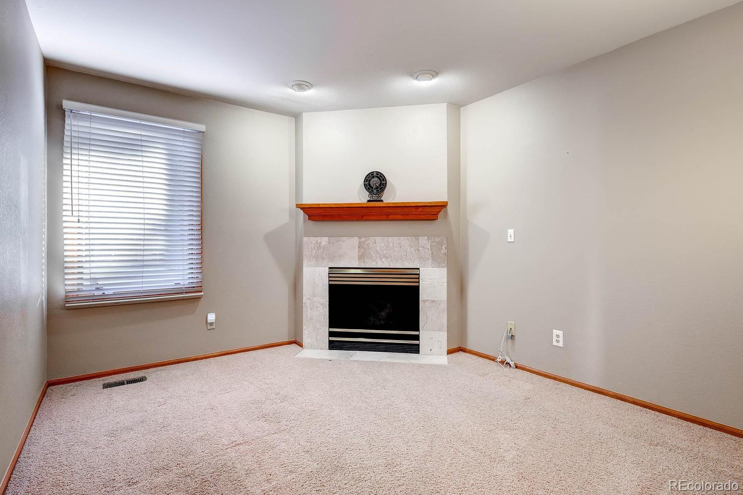 9470 Kemper Drive Lone Tree, CO 80124 - Photo 17 of 35 a living room with a fireplace and a window