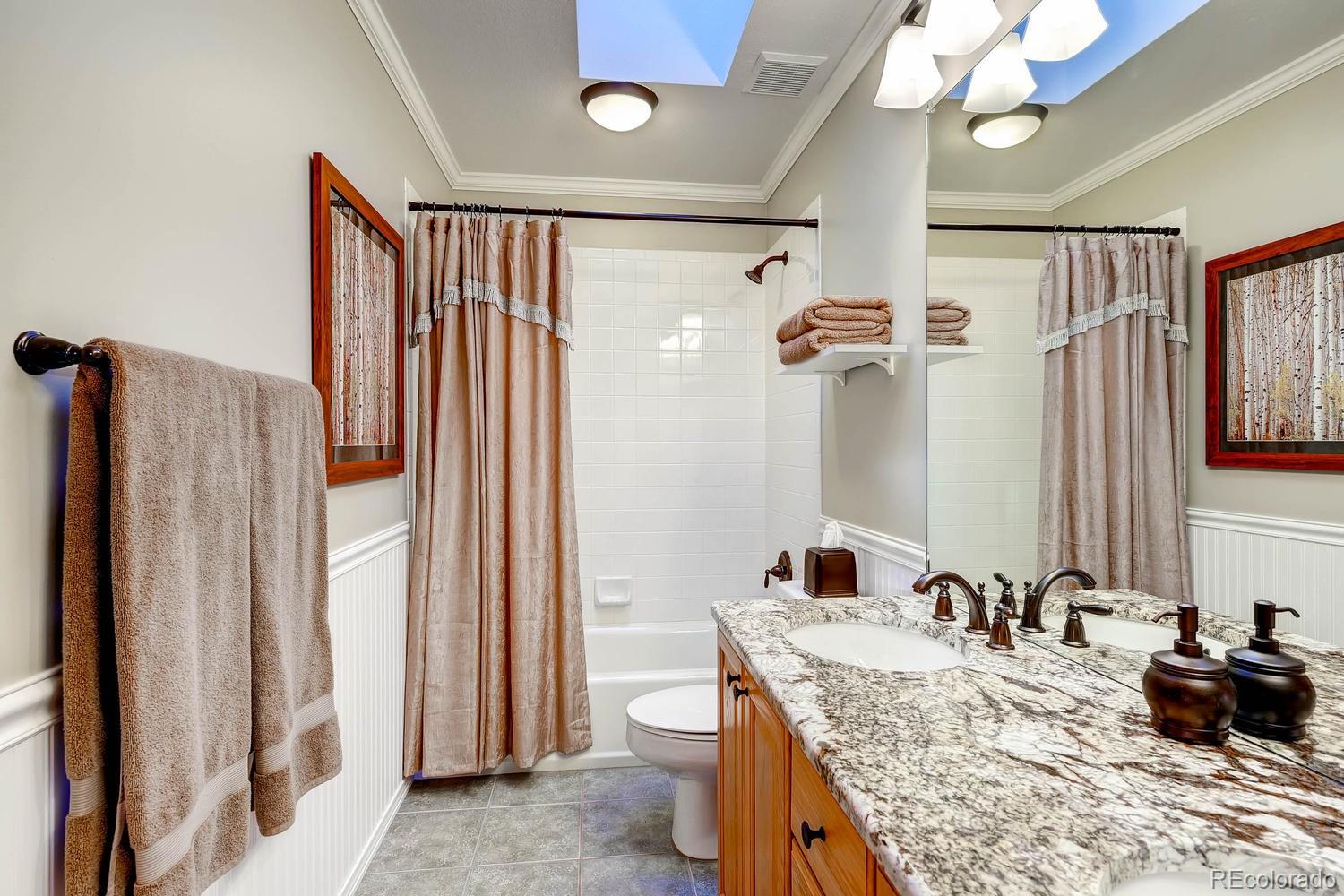 9470 Kemper Drive Lone Tree, CO 80124 - Photo 20 of 35 a bathroom with a granite countertop sink a mirror and shower