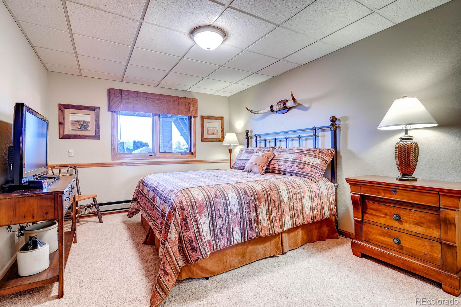 9470 Kemper Drive Lone Tree, CO 80124 - Photo 29 of 35 a bedroom with a bed a dresser next to a window