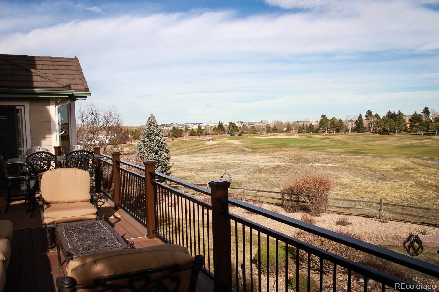 9470 Kemper Drive Lone Tree, CO 80124 - Photo 32 of 35 a view of a balcony with wooden floor chairs and iron fence