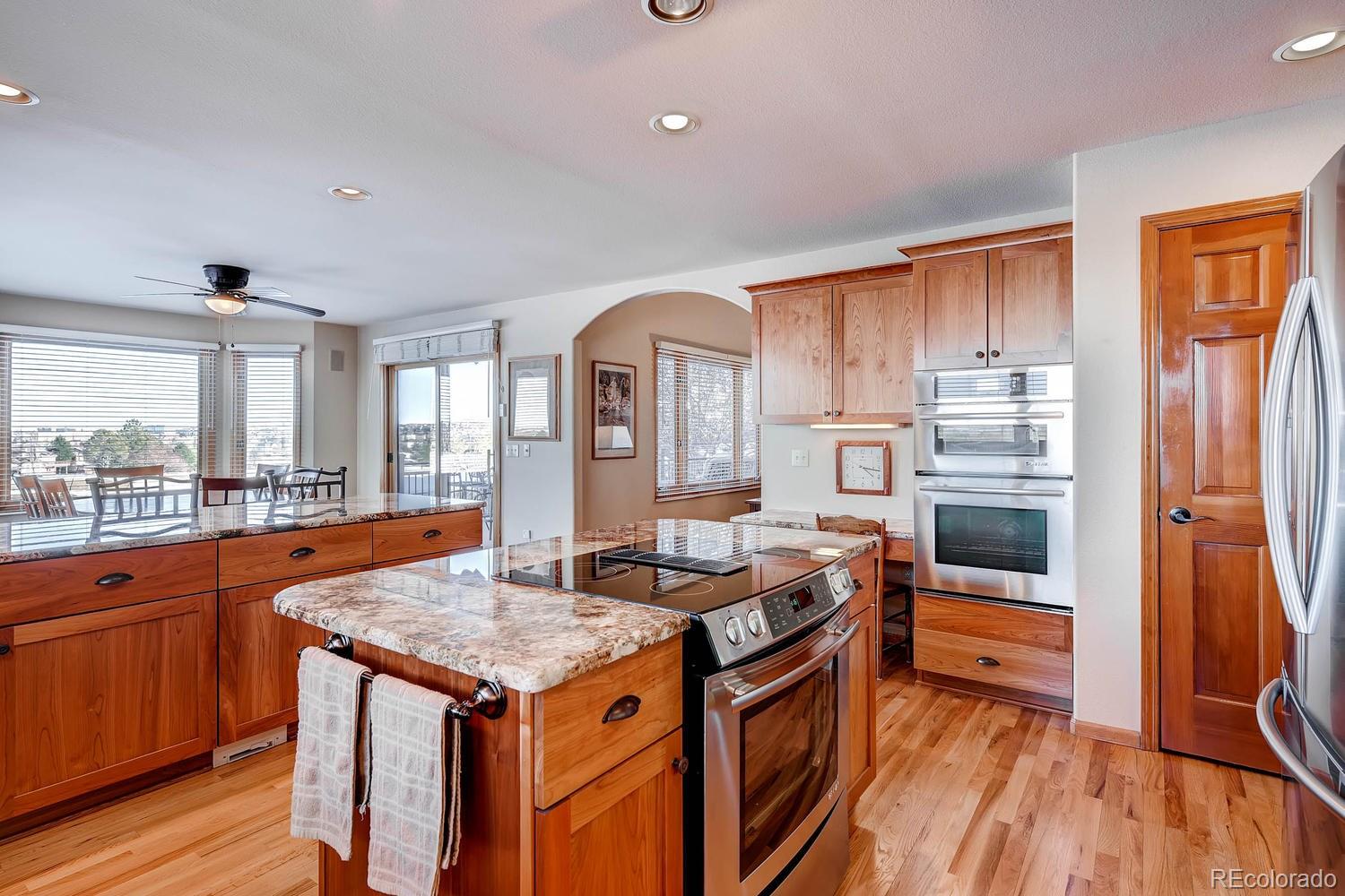 9470 Kemper Drive Lone Tree, CO 80124 - Photo 9 of 35 a kitchen with granite countertop a stove and a refrigerator
