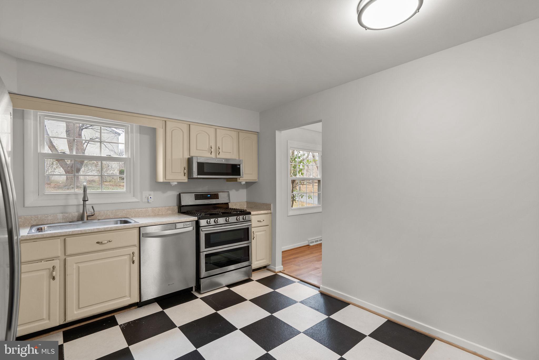 6170 Commodore Court Columbia, MD 21045 - Photo 11 of 49 a kitchen with a sink a stove a microwave and cabinets