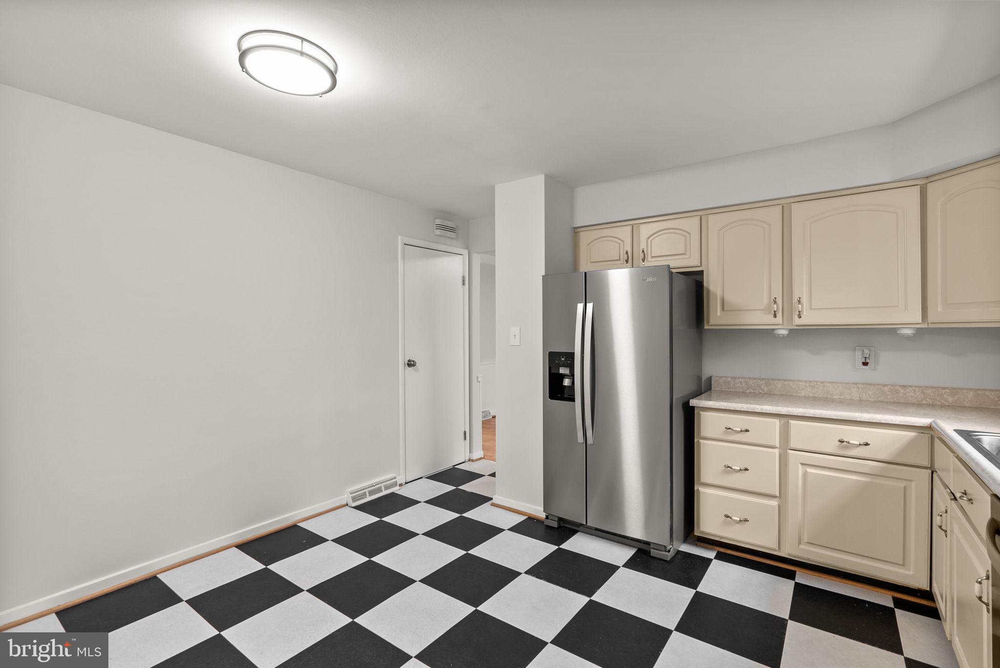6170 Commodore Court Columbia, MD 21045 - Photo 12 of 49 a kitchen with a checkered floor and white cabinets