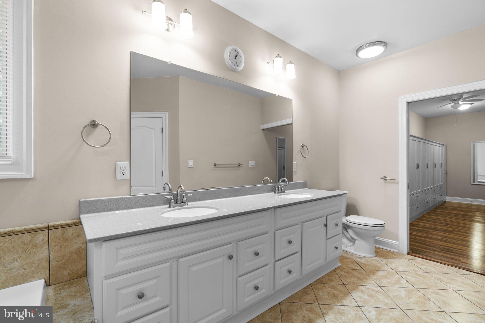 8024 Solley Road Glen Burnie, MD 21060 - Photo 38 of 83 a spacious bathroom with a double vanity sink a toilet and a mirror