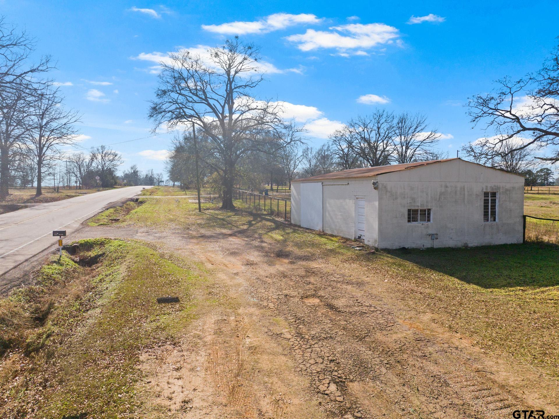 1402 And Nevills Road Mount Pleasant, TX 75455 - Photo 20 of 31 a backyard of a house with a yard and garage