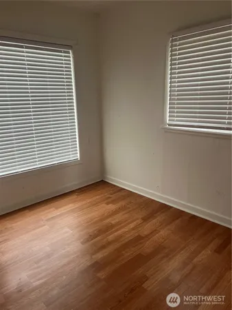 an empty room with wooden floor and a window
