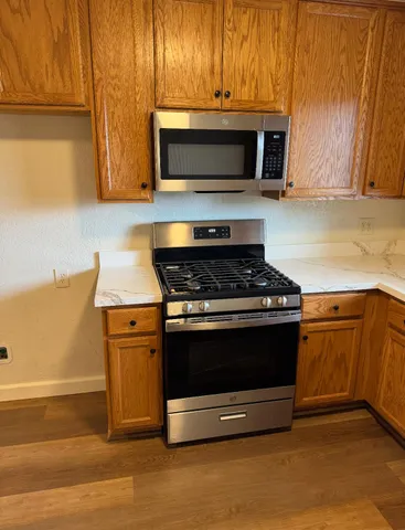a kitchen with granite countertop a stove and a microwave oven