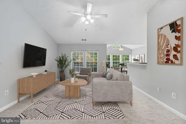 an empty room with chandelier fan and windows