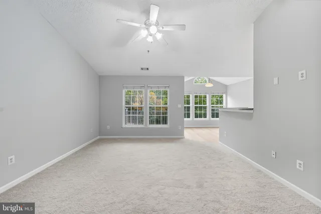 a living room with furniture a flat screen tv and a large window