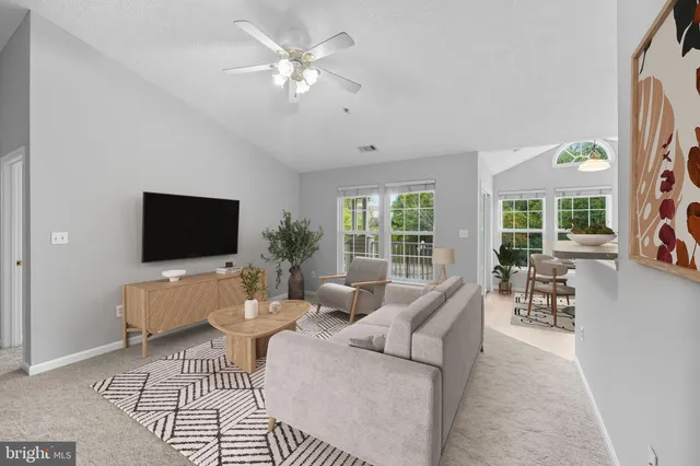 an empty room with chandelier fan and windows