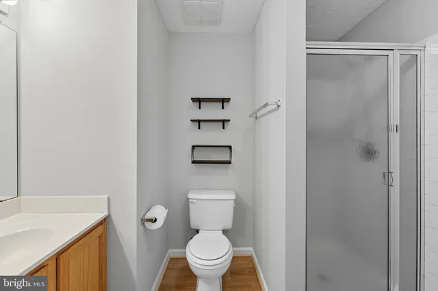 a bathroom with a granite countertop sink toilet and a mirror