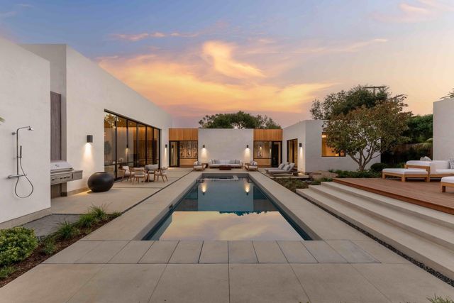 a view of a swimming pool with a yard and trees