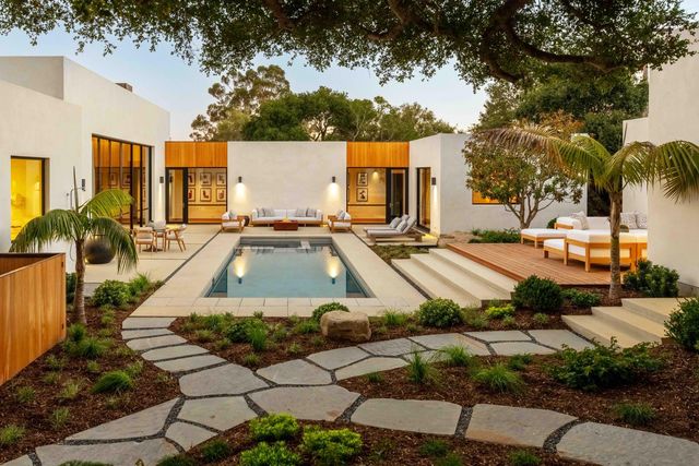 a dining room with wooden floor and large windows