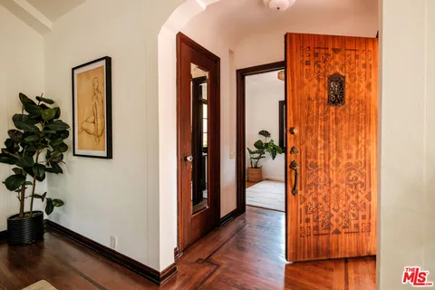 a view of a hallway with wooden floor and a potted plant