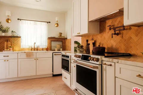 a kitchen with white cabinets and white appliances