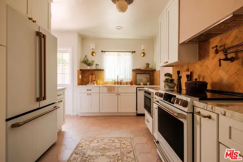 a kitchen with white cabinets and white appliances